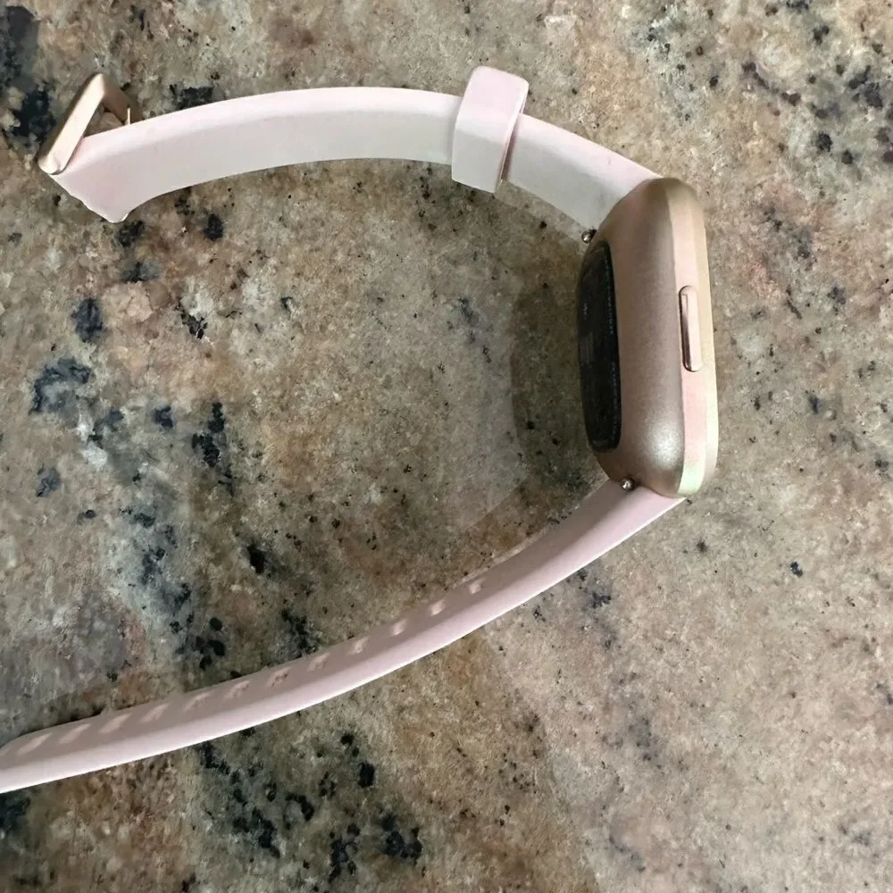 Fitbit versa with pink band and charger